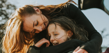 une femme fait un câlin à un enfant