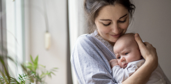une femme tient un bébé dans ses bras